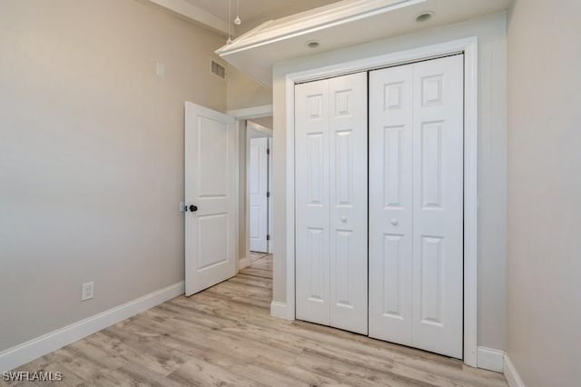 unfurnished bedroom with a closet and light wood-type flooring