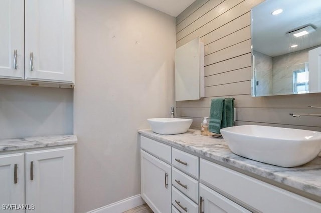 bathroom with vanity, wood walls, and a shower