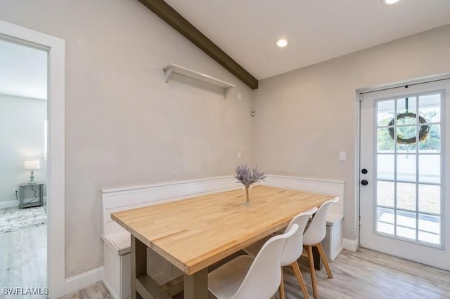 dining room featuring light wood-type flooring and lofted ceiling