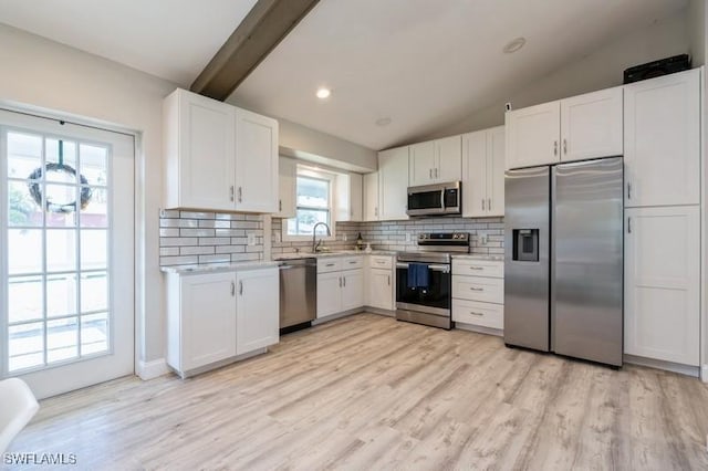 kitchen featuring white cabinets, appliances with stainless steel finishes, tasteful backsplash, and sink