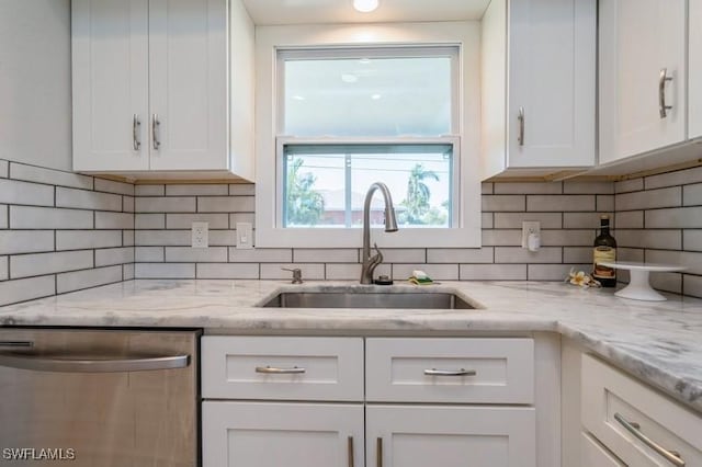 kitchen featuring backsplash, white cabinetry, dishwasher, and sink