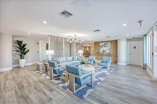 living room featuring light hardwood / wood-style floors and an inviting chandelier