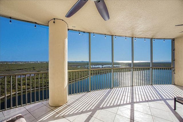 view of patio / terrace featuring ceiling fan, a balcony, and a water view