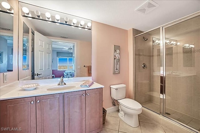 bathroom with tile patterned flooring, vanity, toilet, and walk in shower