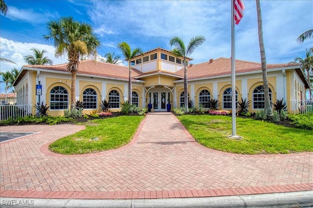 mediterranean / spanish house with a front yard and french doors