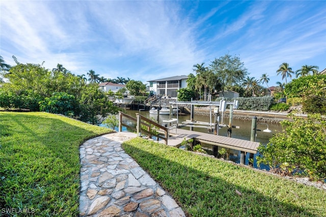 view of dock with a yard and a water view