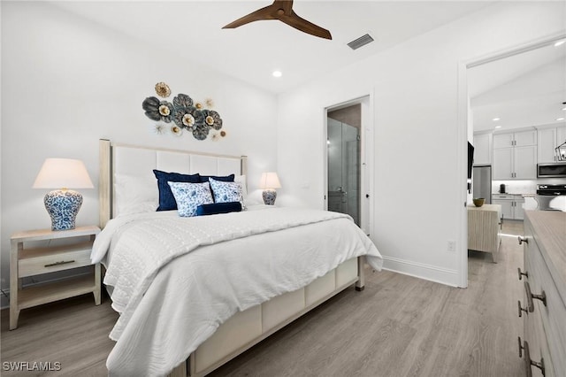 bedroom featuring ceiling fan, stainless steel fridge, connected bathroom, and light hardwood / wood-style flooring