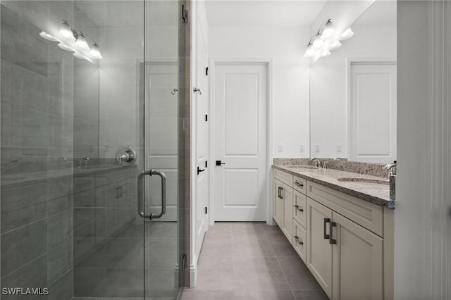 bathroom featuring tile patterned flooring, vanity, and a shower with shower door