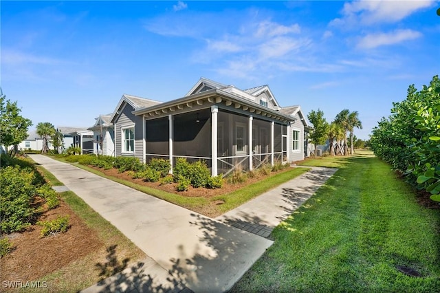 view of property exterior featuring a lawn and a sunroom