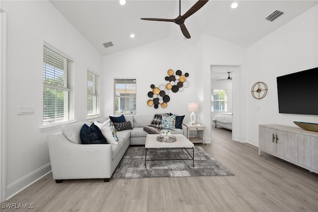 living room featuring plenty of natural light, ceiling fan, light wood-type flooring, and vaulted ceiling