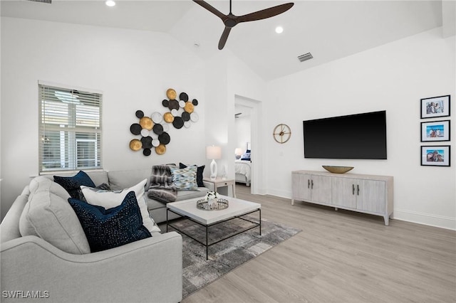 living room featuring ceiling fan, high vaulted ceiling, and light wood-type flooring