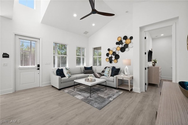 living room featuring ceiling fan, light hardwood / wood-style floors, and high vaulted ceiling