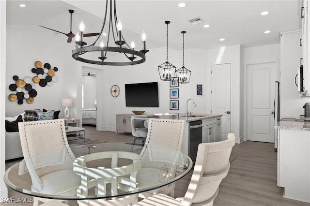 dining space with hardwood / wood-style floors, lofted ceiling, and sink