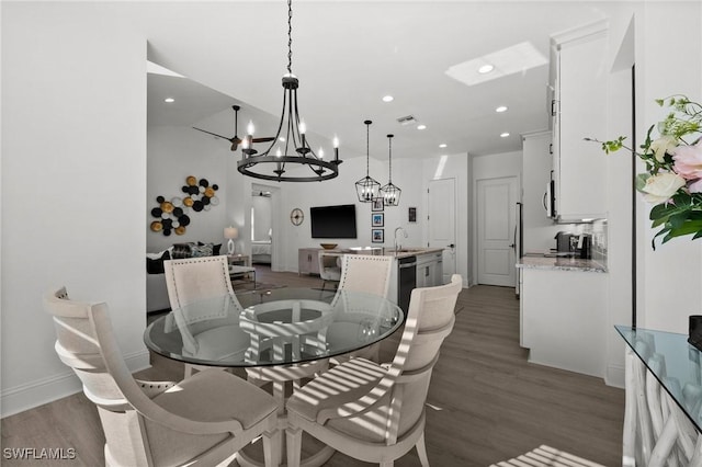 dining space featuring dark hardwood / wood-style floors, an inviting chandelier, and sink