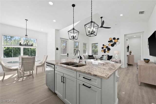 kitchen with an island with sink, stainless steel dishwasher, plenty of natural light, and sink