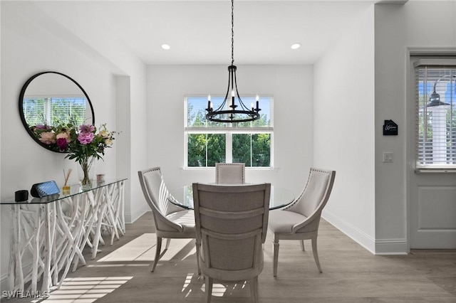 dining area with hardwood / wood-style floors, a notable chandelier, and a wealth of natural light