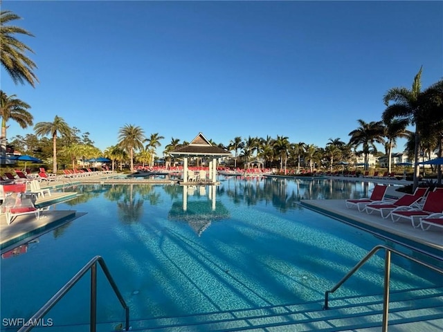 view of swimming pool featuring a water view and a patio