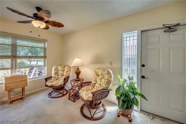 sitting room with carpet, baseboards, and ceiling fan