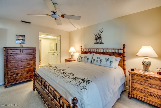 bedroom featuring light carpet, connected bathroom, visible vents, and ceiling fan