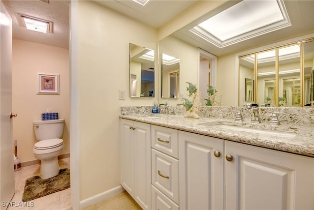 full bathroom featuring double vanity, baseboards, toilet, and a sink