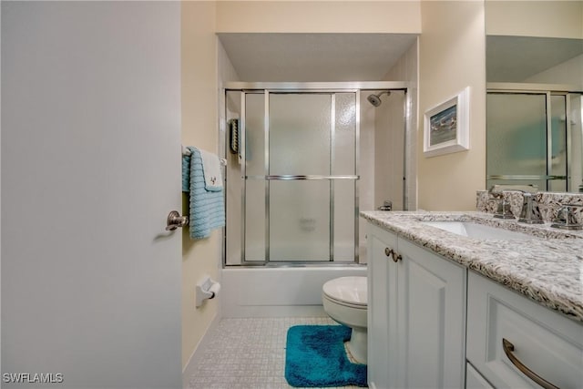 full bath with combined bath / shower with glass door, tile patterned floors, vanity, and toilet