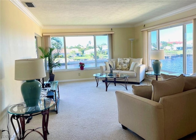 carpeted living room featuring a water view, a wealth of natural light, visible vents, and crown molding