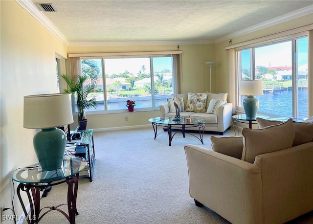 living area with visible vents, baseboards, carpet flooring, and a healthy amount of sunlight