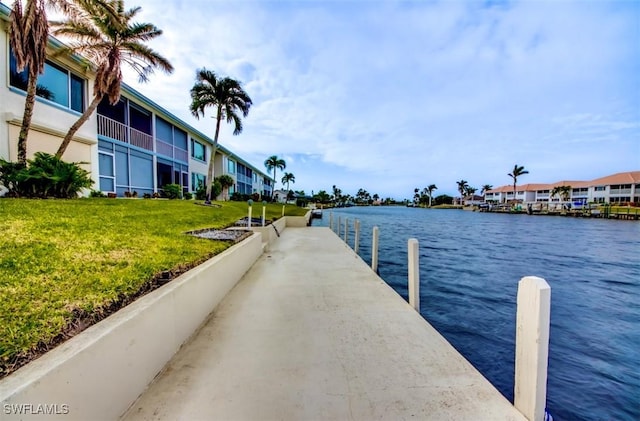dock area featuring a lawn, a residential view, and a water view