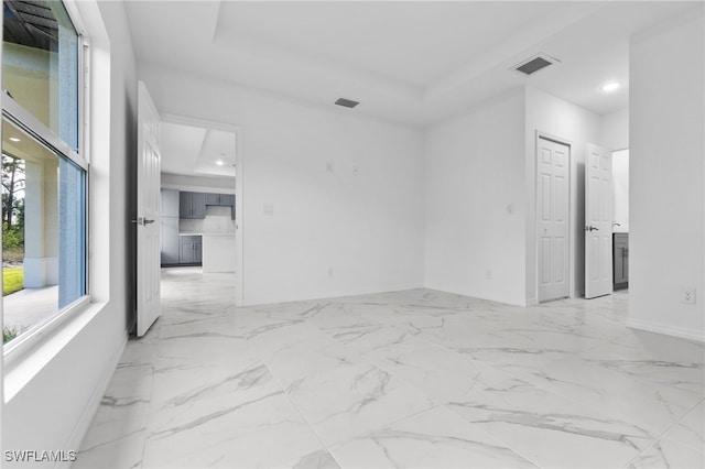 unfurnished room featuring a tray ceiling