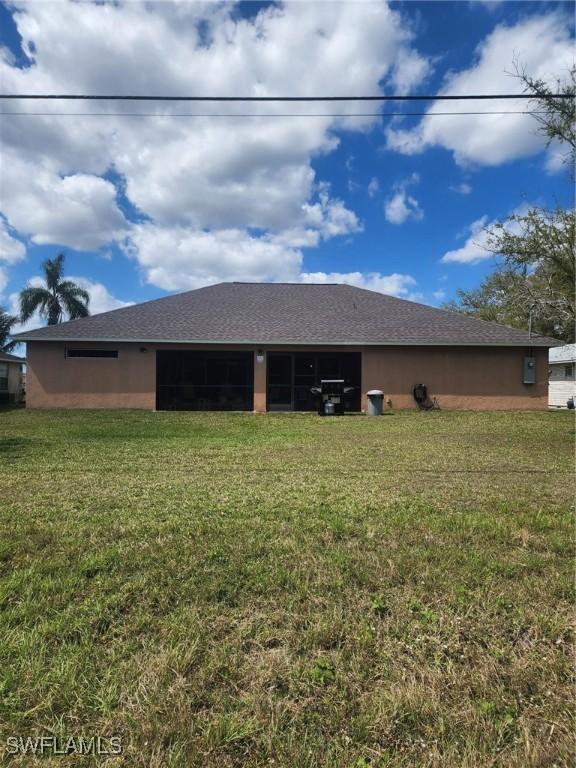 rear view of house featuring a yard