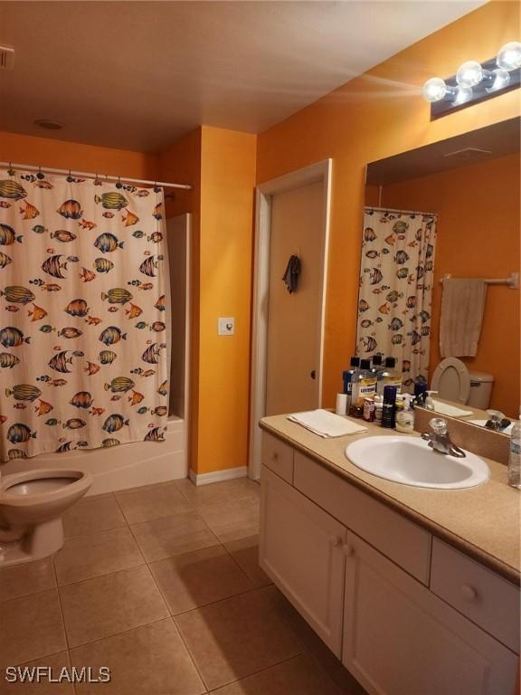 full bathroom with tile patterned floors, vanity, shower / bath combination with curtain, and toilet