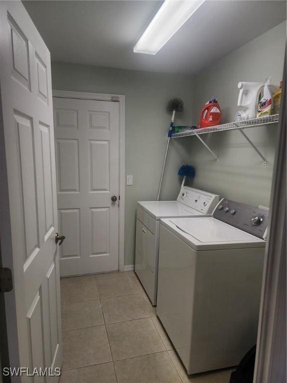 laundry room featuring light tile patterned floors and washing machine and clothes dryer