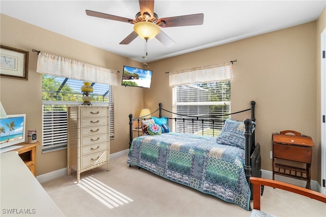 carpeted bedroom featuring multiple windows and ceiling fan