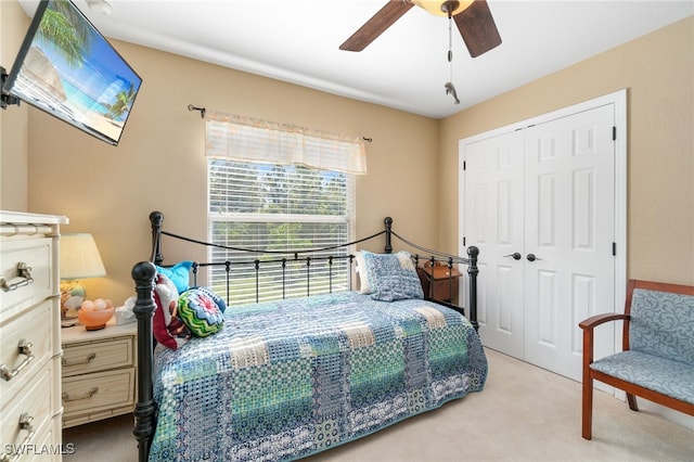 carpeted bedroom with ceiling fan and a closet