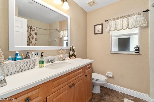 bathroom featuring tile patterned flooring, vanity, curtained shower, and toilet