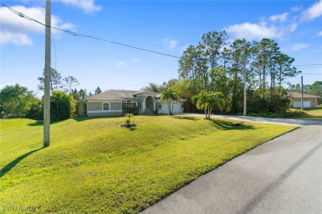 single story home with a garage and a front lawn