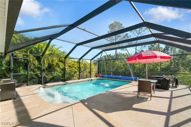 view of pool featuring glass enclosure, pool water feature, and a patio