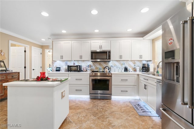 kitchen featuring decorative backsplash, crown molding, white cabinets, and appliances with stainless steel finishes