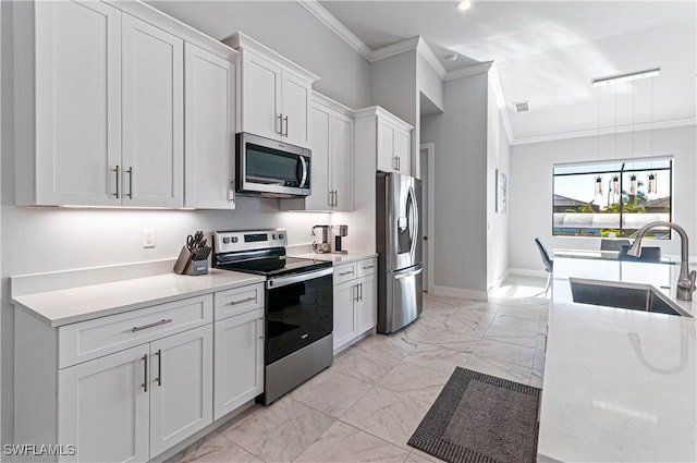 kitchen with white cabinets, appliances with stainless steel finishes, crown molding, and sink