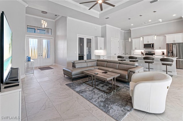 living room with ceiling fan, crown molding, a high ceiling, and french doors