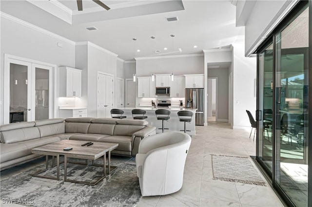 living room featuring a high ceiling, french doors, plenty of natural light, and ornamental molding