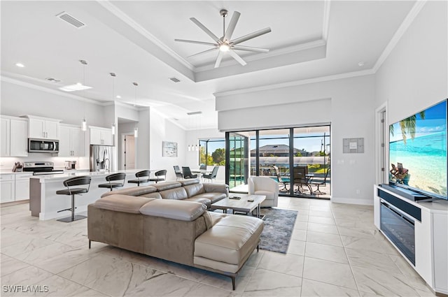 living room with ceiling fan, crown molding, and a high ceiling