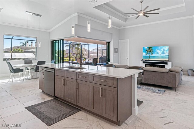 kitchen featuring dishwasher, sink, a wealth of natural light, and an island with sink