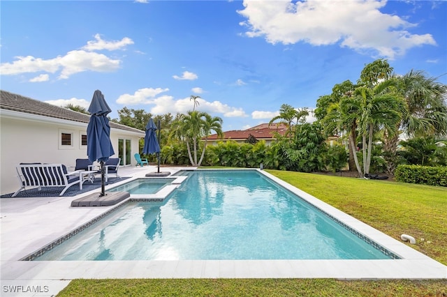 view of swimming pool featuring a lawn, a patio area, and an in ground hot tub