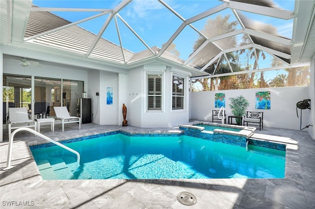 view of swimming pool with an in ground hot tub, a patio, glass enclosure, and ceiling fan