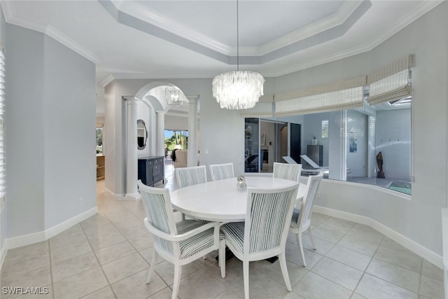 dining room featuring a chandelier, light tile patterned flooring, crown molding, and decorative columns