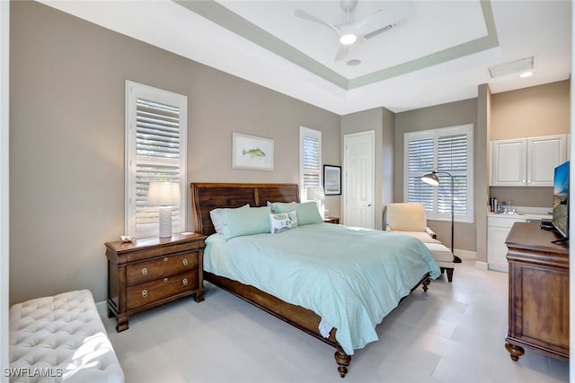 bedroom featuring a closet, a raised ceiling, and ceiling fan