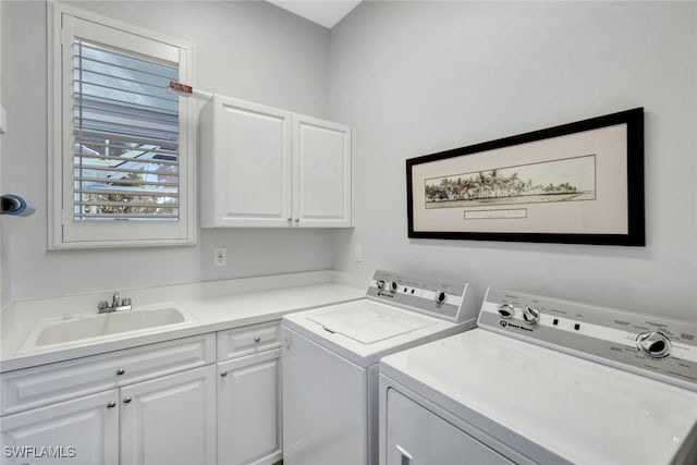 washroom featuring cabinets, independent washer and dryer, and sink