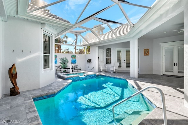 view of pool with a lanai, a patio area, an in ground hot tub, and french doors