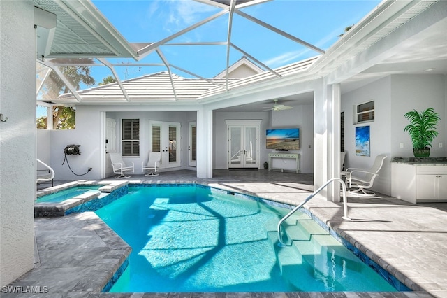 view of swimming pool featuring an in ground hot tub, french doors, a lanai, ceiling fan, and a patio area